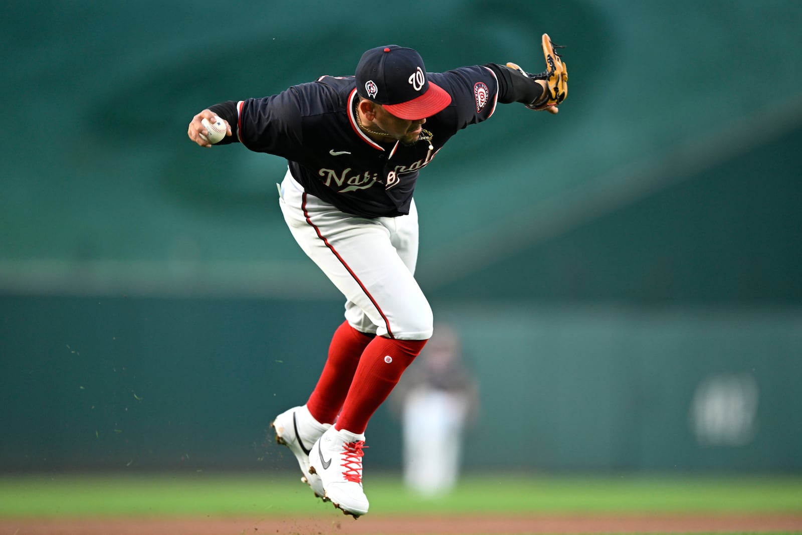 Washington Nationals third baseman Ildemaro Vargas fields a grounder and throws out Atlanta Braves' Orlando Arcia during the second inning of a baseball game, Wednesday, Sept. 11, 2024, in Washington. (AP Photo/John McDonnell)