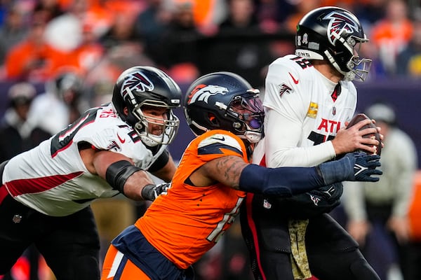 Denver Broncos linebacker Nik Bonitto (15) sacks Atlanta Falcons quarterback Kirk Cousins (18) during the second half of an NFL football game, Sunday, Nov. 17, 2024, in Denver. (AP Photo/Jack Dempsey)