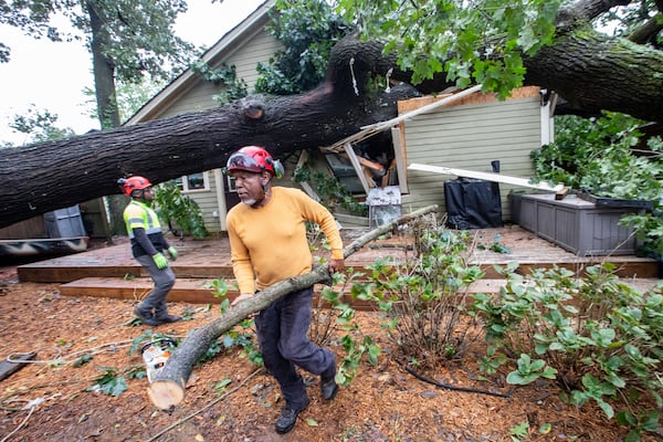 Dad’s Tree Service’s Gary Cooper, front, and Mike Crear, work to remove an oak tree from a Kirkwood home on Friday, Sept 27, 2024 after it fell around 5:45 a.mm during Hurricane Helene. (Jenni Girtman for The Atlanta Journal-Constitution)