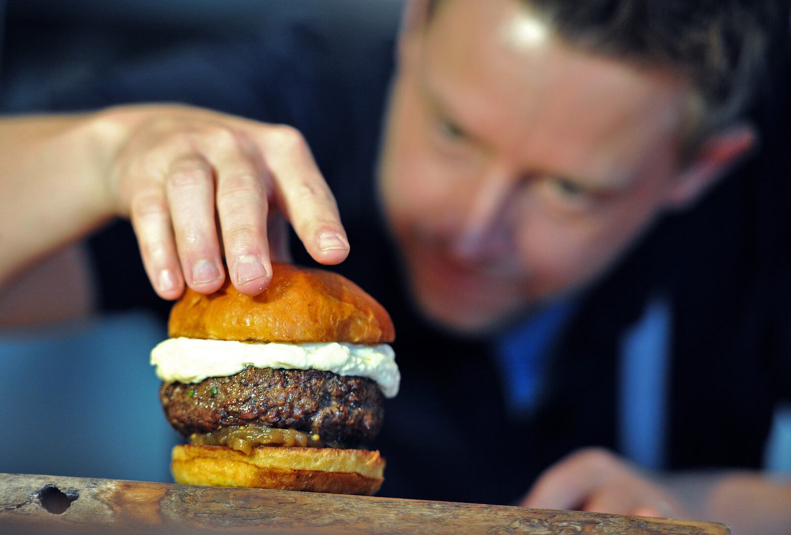 This burger with candied onions, braised bacon and cheddar foam is indicative of the work of chef Richard Blais. Hyosub Shin/hyosub.shin@ajc.com