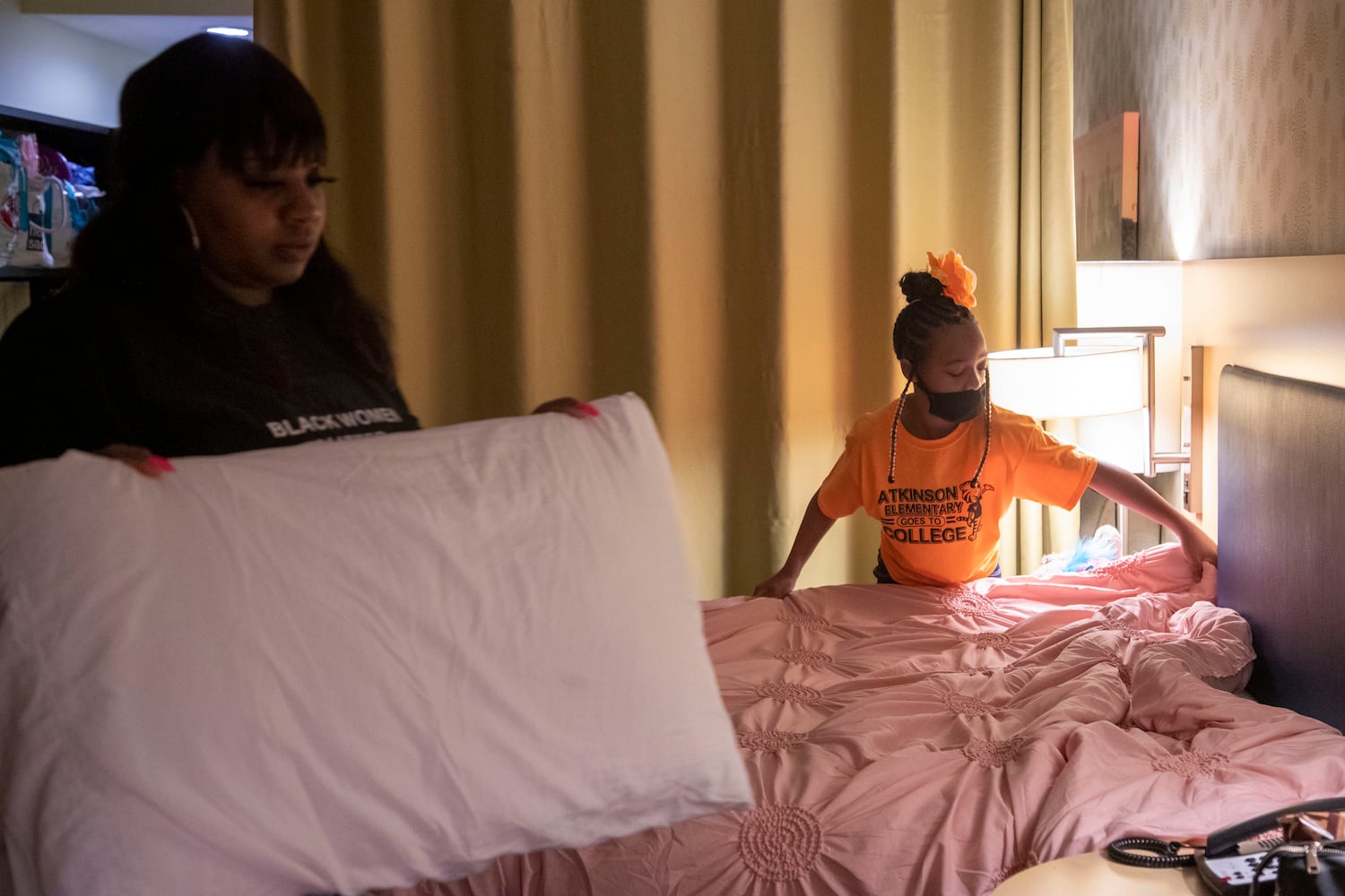 Runyia McKiver, right, helps her mother Brittany Mitchell clean up their hotel room in Newnan. (Alyssa Pointer / Alyssa.Pointer@ajc.com)