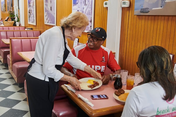 Server Maria Burks delivers a customer's order at the White House diner in Atlanta. (Greg Rannells for The Atlanta Journal-Constitution)