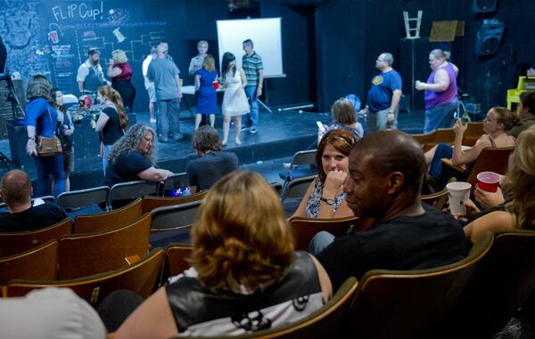 Jon Carr and Allie Southwood talk Saturday as they sit in the audience at Dad’s Garage in Atlanta during the Bringing Down the House Party.  JONATHAN PHILLIPS / For the Atlanta Journal-Constitution