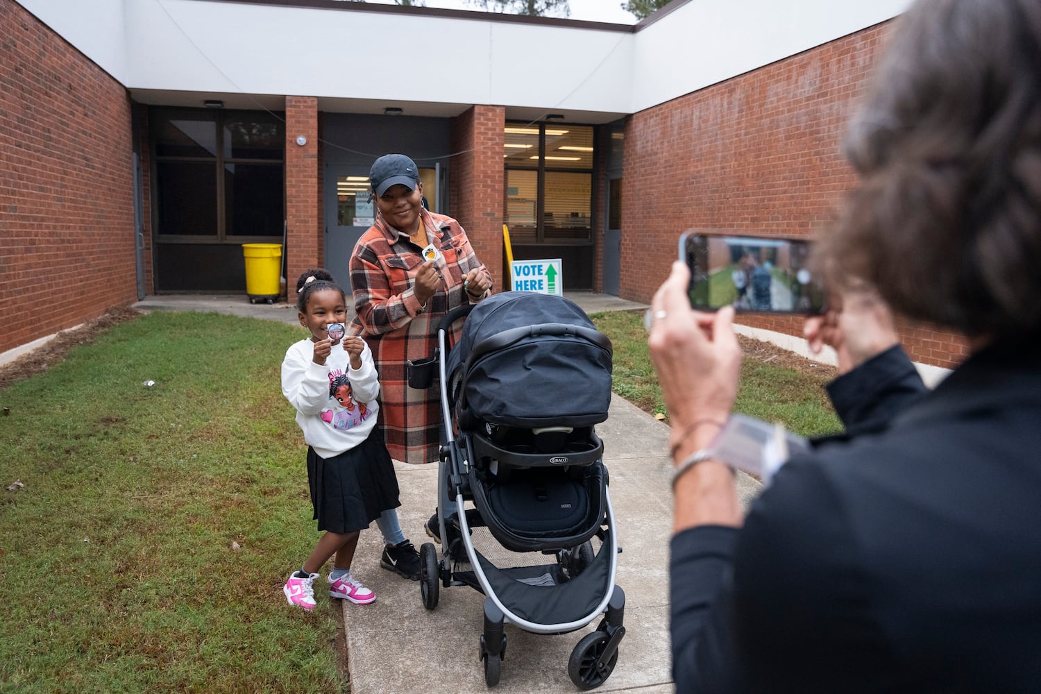 A family poses for a photo outside a polling station at Fairington Elementary in Lithonia, Georgia on Election Day, Tuesday, Nov. 5, 2024. (Olivia Bowdoin for the AJC). 