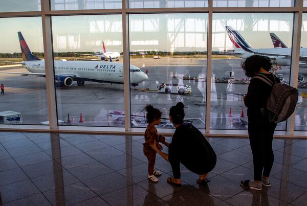 The setting sun lights up the international terminal at Hartsfield-Jackson Atlanta Airport as travelers make their way to their flight Tuesday, May 10, 2022. (Steve Schaefer / steve.schaefer@ajc.com)
