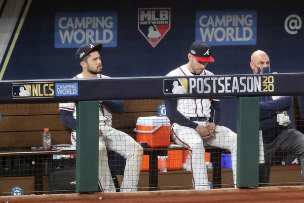 Braves catcher Travis d'Arnaud (left) and first baseman Freddie Freeman rest in the dugout after they were removed from the game against the Los Angeles Dodgers during the sixth inning Wednesday, Oct. 14, 2020, at Globe Life Field in Arlington, Texas. (Curtis Compton / Curtis.Compton@ajc.com)



