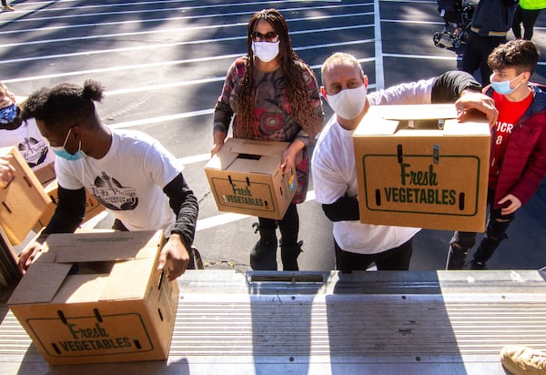 Volunteers load a U-Haul with some of the 3,600 food boxes trucked in on three semi-trucks Saturday in Norcross on November 21, 2020.    STEVE SCHAEFER / SPECIAL TO THE AJC 