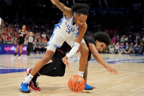 Duke guard Isaiah Evans and Louisville forward Aboubacar Traore battle for a loose ball during the first half of an NCAA college basketball game in the championship of the Atlantic Coast Conference tournament, Saturday, March 15, 2025, in Charlotte, N.C. (AP Photo/Chris Carlson)