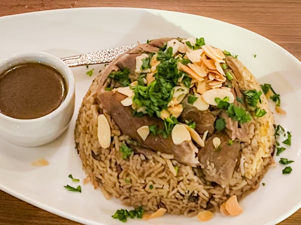 The upside-down lamb pilaf at Bey Mediterranean is a mountain of Middle Eastern comfort food. (Henri Hollis/henri.hollis@ajc.com)