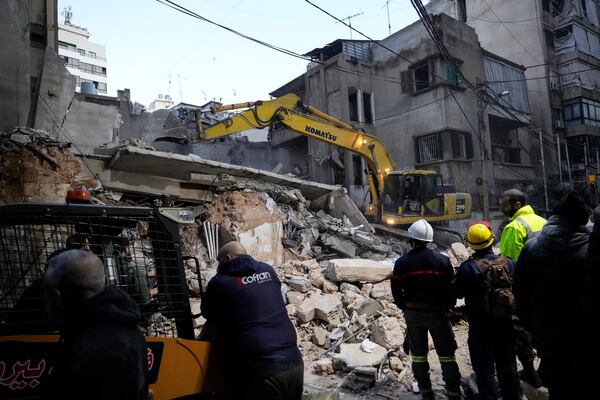 Rescuers use an excavator as they search for victims at the site of an Israeli airstrike that hit a building in Beirut, Lebanon, Tuesday, Nov. 26, 2024. (AP Photo/Hassan Ammar)