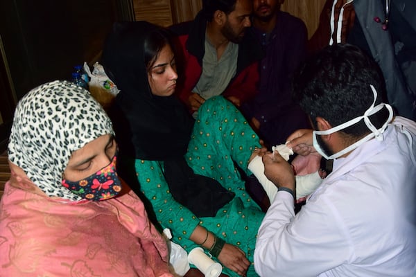 A passenger receives medical treatment upon her arrival at a railway station in Quetta, Pakistan, Wednesday, March 12, 2025, after being rescued by security forces from a passenger train attacked by insurgents. (AP Photo/Arshad Butt)