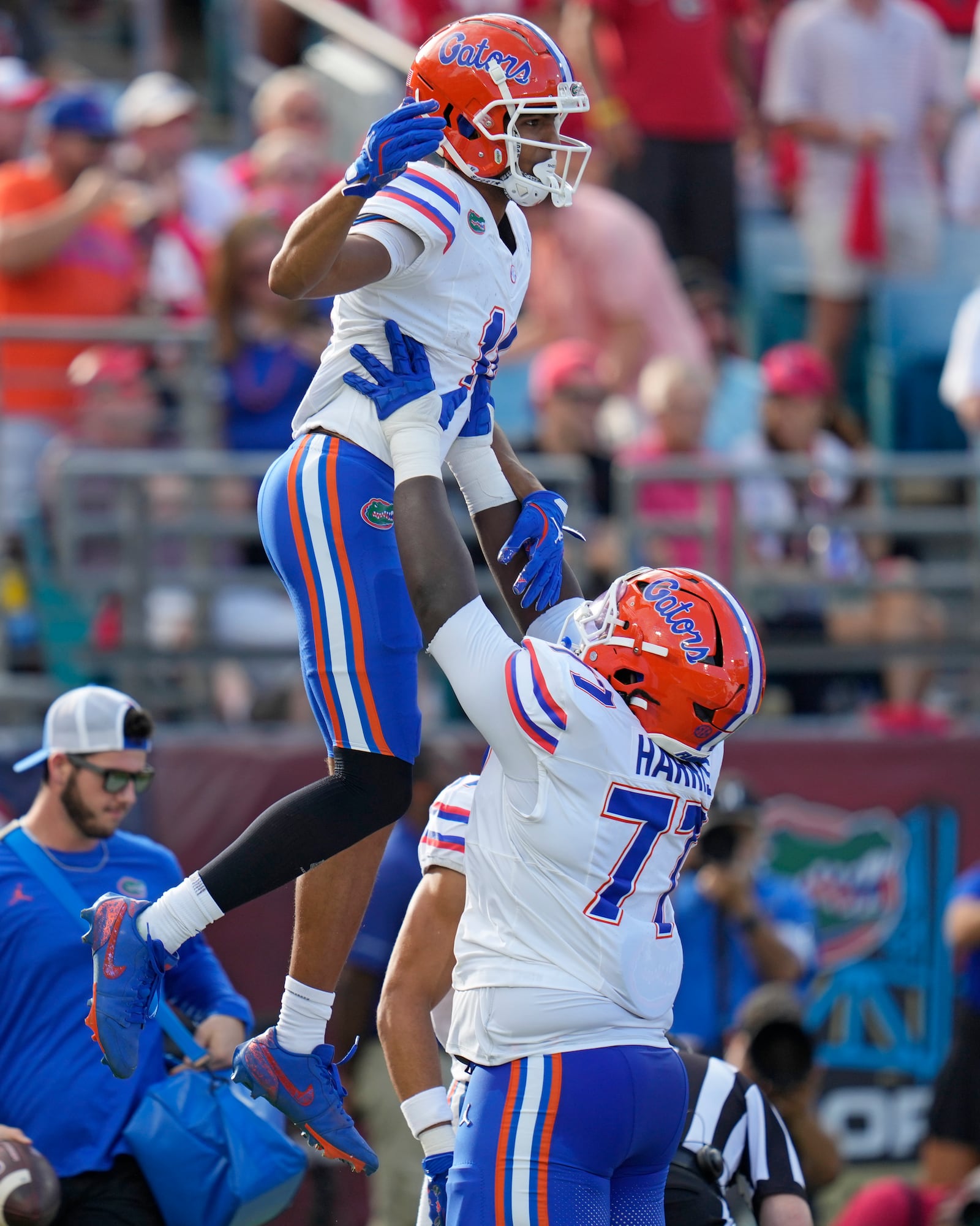 Florida wide receiver Aidan Mizell, left, jumps in the arms of offensive lineman Knijeah Harris after scoring a touchdown on a pass play during the first half of an NCAA college football game against Georgia, Saturday, Nov. 2, 2024, in Jacksonville, Fla. (AP Photo/John Raoux)