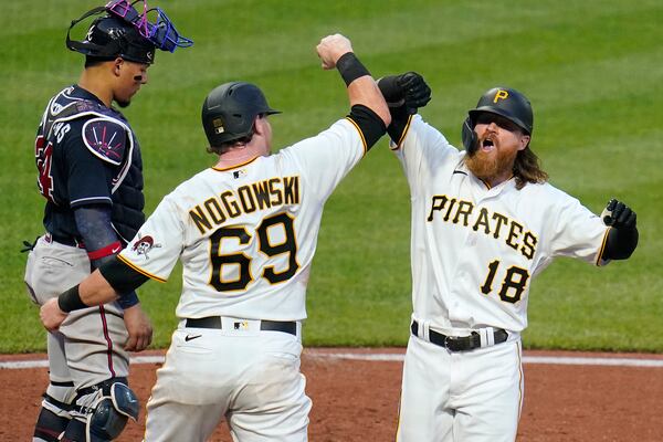 Pittsburgh Pirates' Ben Gamel (18) celebrates with John Nogowski (69) as he crosses home plate in front of Atlanta Braves catcher William Contreras after hitting a two-run home run off starting pitcher Max Fried during the fourth inning of a baseball game in Pittsburgh, Monday, July 5, 2021. (AP Photo/Gene J. Puskar)