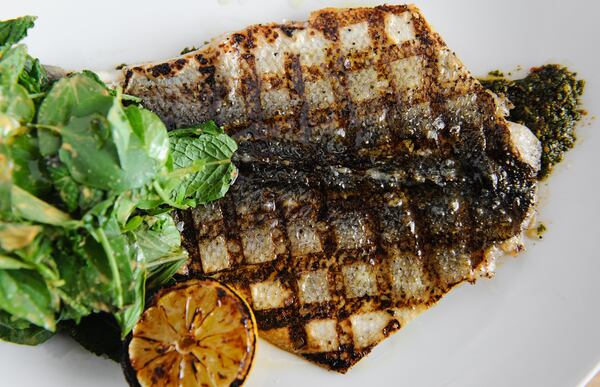 Wood grilled branzino- charmoula, seven herb salad, charred lemon at Drift. / (BECKY STEIN PHOTOGRAPHY)