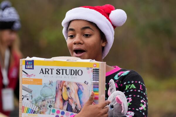 Khylin Barber reacts to a gift she received during the 82nd run of the CSX Santa Train, Saturday, Nov. 23, 2024, in Dungannon, Va. (AP Photo/George Walker IV)