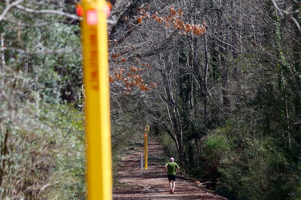 A jogger exercises at the intramural fields as he approaches an emergency call station on the east side of the UGA campus on Tuesday, Feb. 18, 2025. One year after the murder of Laken Riley, the University of Georgia has allocated millions of dollars toward safety enhancements. (Miguel Martinez/AJC)