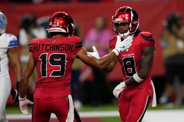 Houston Texans wide receiver John Metchie III (8) celebrates with teammate Xavier Hutchinson (19) after catching a 15-yard touchdown pass during the first half of an NFL football game against the Detroit Lions, Sunday, Nov. 10, 2024, in Houston. (AP Photo/David J. Phillip)