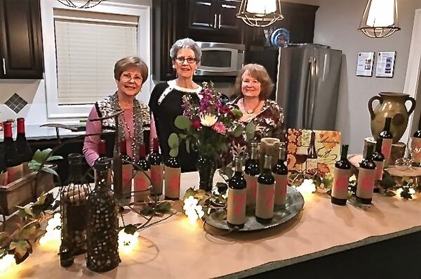 Using the clubhouse to host a wine tasting event, committee members set up a display.