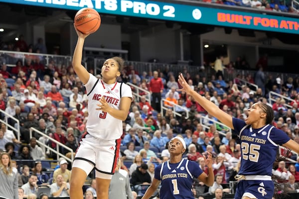 North Carolina State guard Zamareya Jones (3) drives past Georgia Tech guard Kara Dunn (25) and guard Chazadi Wright (1) during an NCAA college basketball game in the quarterfinals of the Atlantic Coast Conference tournament Greensboro, N.C., Friday, March 7, 2025. (AP Photo/Chuck Burton)