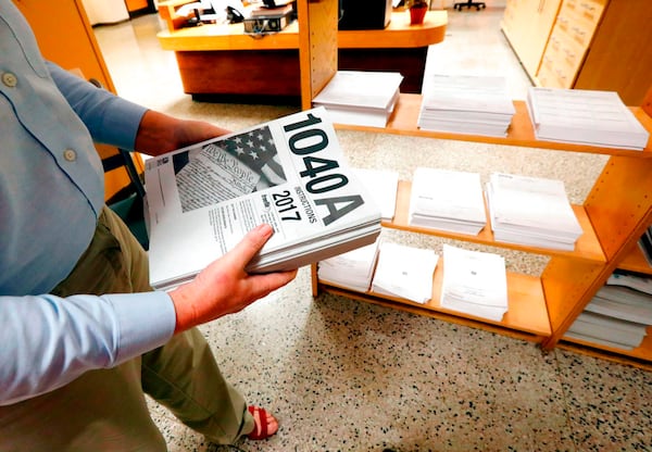 FILE- In this Feb. 15, 2018, photo, Susan Prendergast, reference supervisor at the Eudora Welty Library, in Jackson, Miss., adds additional federal tax filing information booklets on a shelf. The tax deadline does typically fall on April 15 but thatâs a Sunday this year and Monday is Emancipation Day, a Washington D.C. holiday. That means that taxpayers nationwide get a little breathing room and have until Tuesday, April 17, to get the job done. (AP Photo/Rogelio V. Solis, File)