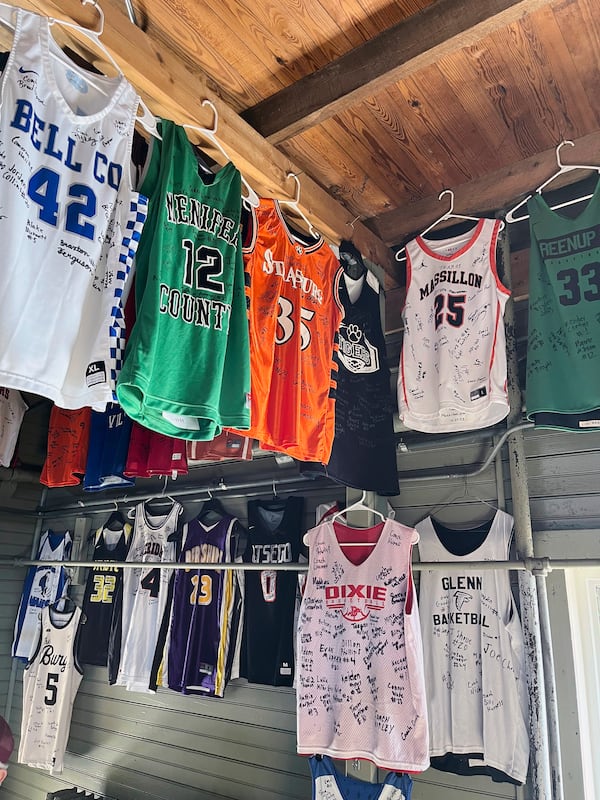 FILE - Signed jerseys left behind by high school teams hang at The Hoosier Gym, where many scenes from the movie "Hoosiers" was filmed in the mid-1980s plays host to dozens of high school games each year as fans still flock to the site, Monday, Feb. 19, 2024, in Knightstown, Ind. (AP Photo/Tim Reynolds, File)