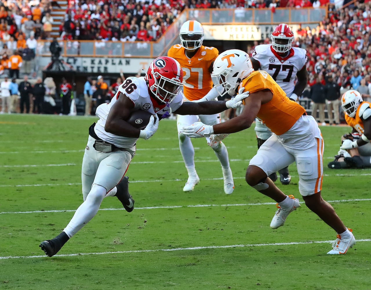 Georgia wide receiver Dillon Bell breaks away from Tennessee defender Gabe Jeudy-Lally for a touchdown to take a 17-7 lead during the second quarter in a NCAA college football game on Saturday, Nov. 18, 2023, in Knoxville.  Curtis Compton for the Atlanta Journal Constitution