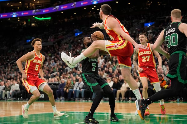 Boston Celtics' Jaylen Brown (7) avoids a shot block-attempt by Atlanta Hawks' Garrison Mathews, third from right, during the first half of an NBA basketball game, Saturday, Jan. 18, 2025, in Boston. (AP Photo/Robert F. Bukaty)