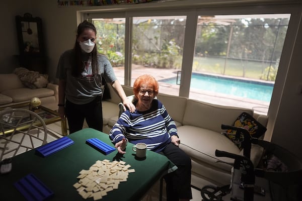 Kira Levin, 29, left, stands with her 98-year-old grandmother Jeanette Levin, in their living room in Pinecrest, Fla., Monday, Dec. 16, 2024. Kira, who moved back in with her parents when COVID hit as she was finishing her masters degree, has become a primary caregiver to her grandmother while also working from home. (AP Photo/Rebecca Blackwell)