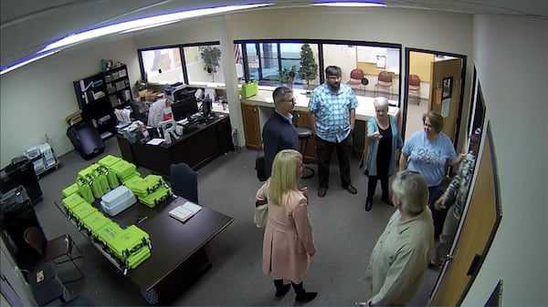 Surveillance video of the Coffee County elections office shows green voter check-in tablets, called PollPads, on a table while tech experts and supporters of then-President Donald Trump examined elections equipment on Jan. 7, 2021. Source: Coffee County