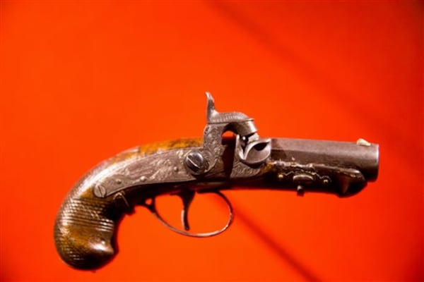 FILE - In this March 17, 2015 file photo, John Wilkes Booth's pistol used to kill President Abraham Lincoln is displayed at a new exhibit entitled "Silent Witnesses: Artifacts of the Lincoln Assassination" at the Ford's Center for Education and Leadership across the street from the historic Ford's Theatre, in Washington. The exhibit is open to the public until May 25, and coincides with the 150th anniversary of the Lincoln assassination on April 14. (AP Photo/Andrew Harnik, File)