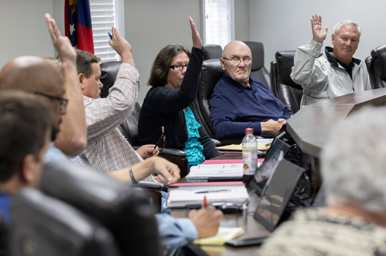 Mary Ellen Anton (center) calls for a vote as the Morgan County board of assessors approve the Rivian tax exemption proposal in Madison on Wednesday, May 25, 2022. John Artz (center right) opposed the measure.  (Bob Andres / robert.andres@ajc.com)