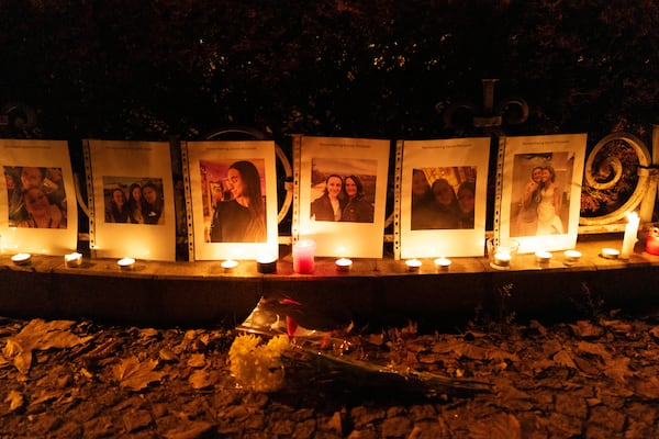 Photos showing Mackenzie Michalski, an 31-year-old American tourist who was murdered while on vacation, hang at a candlelight vigil in Budapest, Hungary, Saturday, Nov. 9, 2024. (AP Photo/Bela Szandelszky)