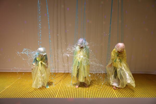 Onyx Barnes, 3, left, and her seven-year-old twin sisters Nuri, center, and Navali Barnes (yellow shirt) of McDonough, gets slimed in the slime-filed experience of Sloomoo in Buckhead, Wednesday, November 16, 2022, in Atlanta. Jason Getz / Jason.Getz@ajc.com)