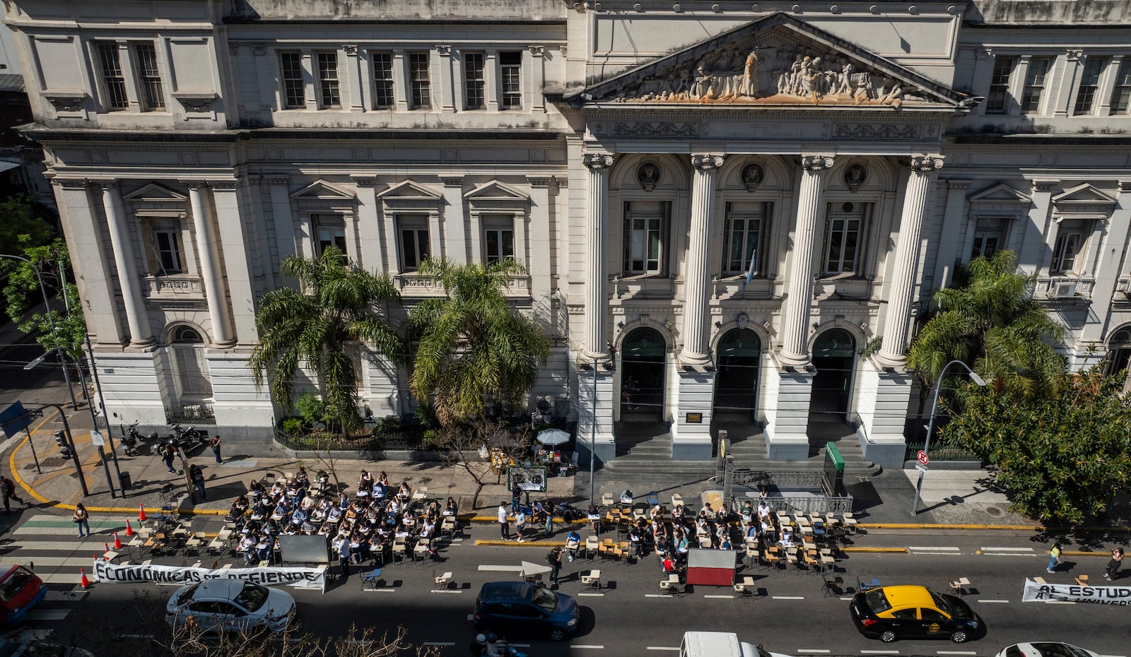 Economics students hold class outside in front of the University of Buenos Aires to protest President Javier Milei's veto of higher funding for public universities in Buenos Aires, Argentina, Wednesday, Oct. 16, 2024. (AP Photo/Victor R. Caivano)