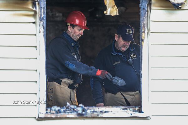 Fire crews go over a house in Forest Park that was the scene of a fatal blaze. JOHN SPINK / JSPINK@AJC.COM