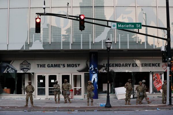 Members of the Georgia National Guard stand in front of the of the College Football Hall of Fame Saturday in the aftermath of  demonstrations against police violence. (AP Photo/Brynn Anderson)