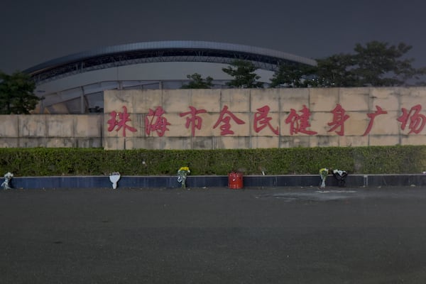 Flowers are placed near a sign which reads "Zhuhai People's Fitness Plaza" where a man deliberately rammed his car into people exercising at the sports center, killed some and injured others in Zhuhai in southern China's Guangdong province, Tuesday, Nov. 12, 2024. (AP Photo/Ng Han Guan)