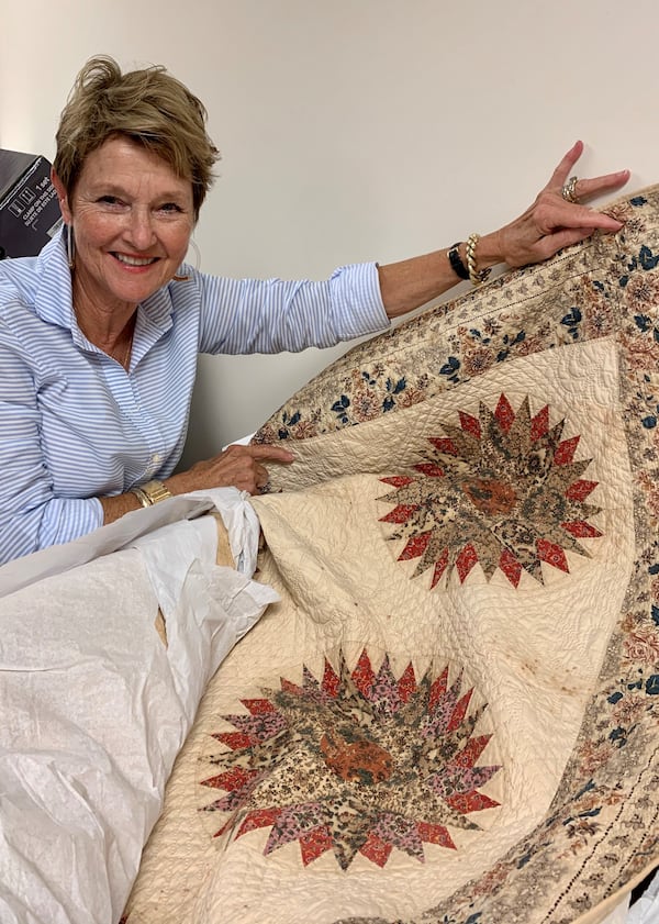 Marilyn Hubbard, Carrollton’s Southeastern Quilt & Textile Museum board president, shows off a Mariner' s Compass quilt from 1834. Howard Pousner/For The AJC