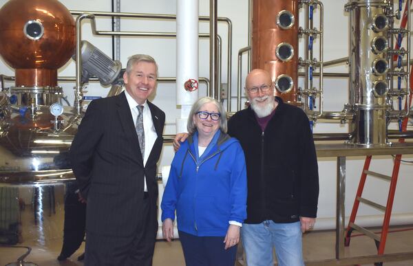 Hope Springs Distillery owners Paul Allen and Betsey Dahlberg pose with Congressman Rob Woodall at the distillery, where Allen and Dahlberg have been making hand sanitizer in addition to their distilled spirits.