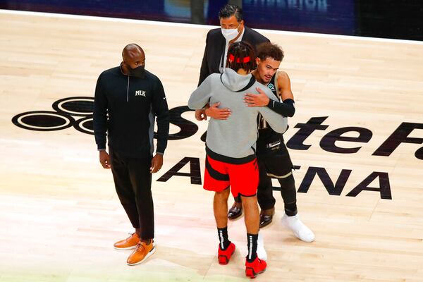 Hawks guard Trae Young (right) and coach Lloyd Pierce (left) greet former Hawks player DeAndre' Bembry after the game. (AP Photo/Todd Kirkland)