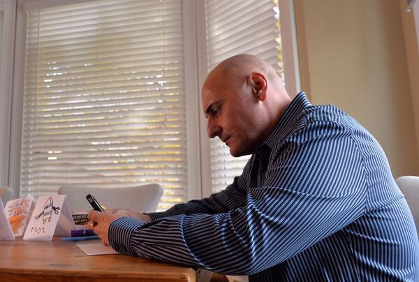 Nick Cellini uses his phone to research the latest happenings in sports. Cellini prepped even when he wasn't working. This was shot in the fall of 2014. BRANT SANDERLIN / BSANDERLIN@AJC.COM