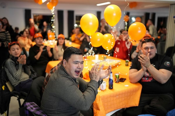 Members of the Naleraq party applaud during a party after parliamentary elections in Nuuk, Greenland, Tuesday, March 11, 2025. (AP Photo/Evgeniy Maloletka)