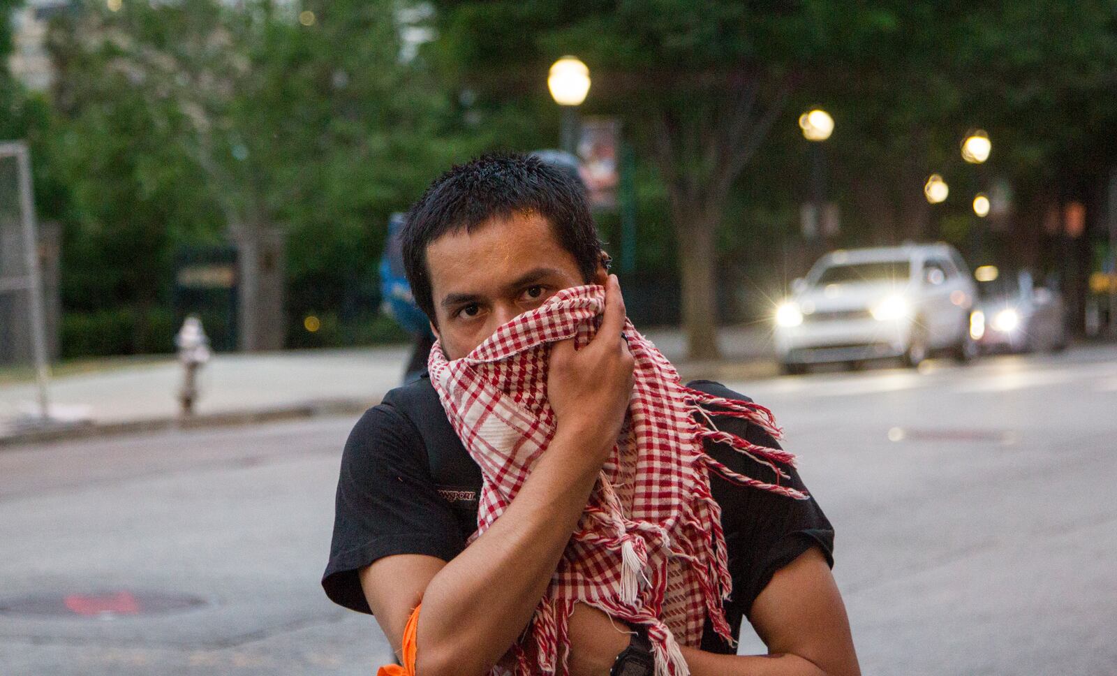 Micha Chishtia, a member of International Socialist Atlanta, holds a scarf to his face at the emergency protest for the violence in Gaza in Downtown Atlanta, Georgia, on Tuesday, May 15, 2018. (REANN HUBER/REANN.HUBER@AJC.COM)