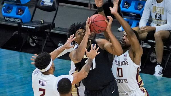 Colorado forward Evan Battey (21) is swarmed by Florida State guard Anthony Polite (2) and teammate Malik Osborne (10) during the second half of a second-round game in the NCAA college basketball tournament at Farmers Coliseum in Indianapolis, Monday, March 22, 2021. (AP Photo/Charles Rex Arbogast)