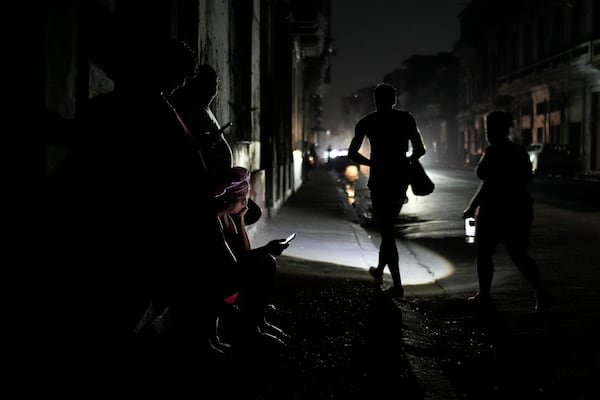 Residents walk on a street during a general blackout in Havana, Cuba, Friday, March 14, 2025. (AP Photo/Ramon Espinosa)