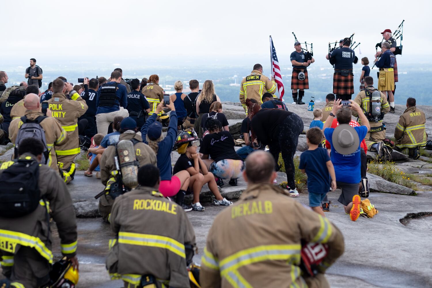 Firefighters take a knee and listen to “Amazing Grace”  atop Stone Mountain on Sunday morning, Sept. 11, 2022, during the annual remembrance of the 9/11 terrorist attacks. (Photo: Ben Gray for The Atlanta Journal-Constitution)