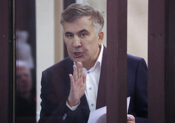 FILE - Former Georgian President Mikheil Saakashvili who was convicted in absentia of abuse of power during his presidency and arrested upon his return from exile, gestures speaking from a defendant's dock during a court hearing in Tbilisi, Georgia, Thursday, Dec. 2, 2021. . (Irakli Gedenidze/Pool Photo via AP, File)