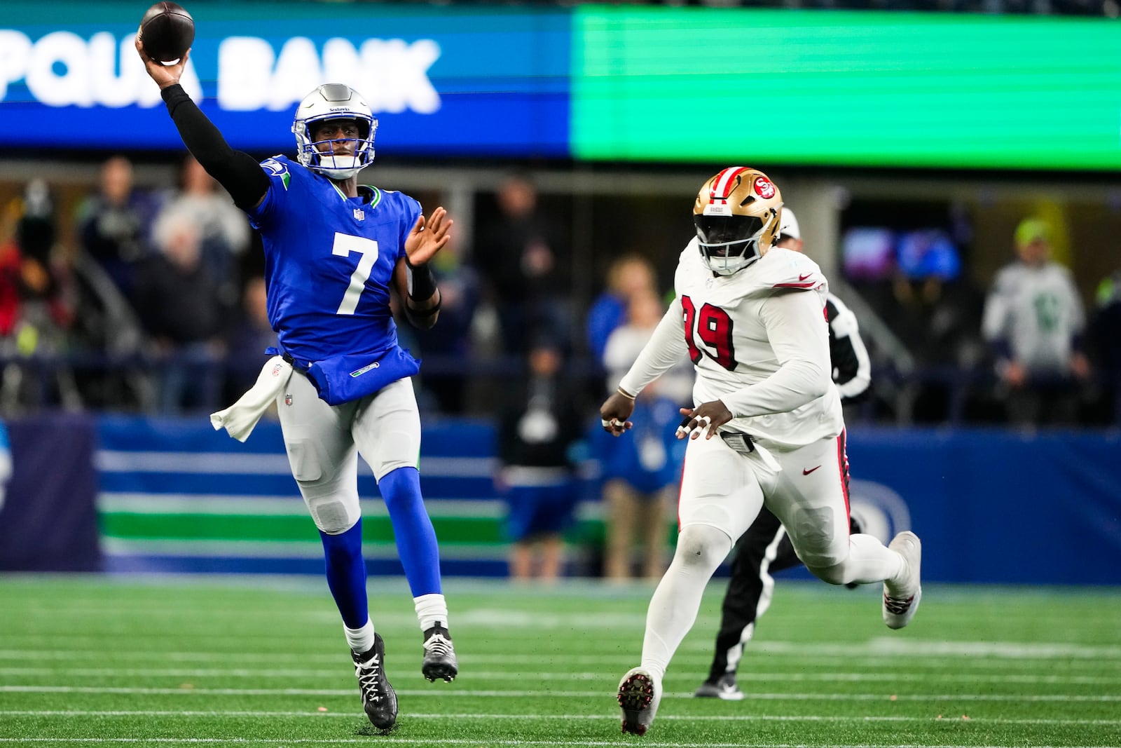 Seattle Seahawks quarterback Geno Smith (7) makes a throw under pressure from San Francisco 49ers defensive tackle Maliek Collins (99) during the second half of an NFL football game Thursday, Oct. 10, 2024 in Seattle. (AP Photo/Lindsey Wasson)