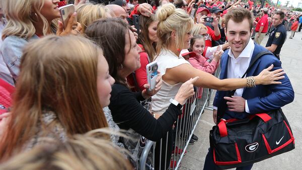 Georgia quarterback Jake Fromm gets a hug from his mother, Lee Fromm, during the team arrival for the Georgia-Florida  game Saturday, Oct. 27, 2018, in Jacksonville, Fla.