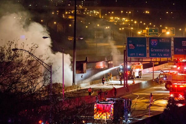 Smoke billows from a section of an overpass that collapsed from a large fire on Interstate 85 in Atlanta, Thursday, March 30, 2017. Atlanta officials say a massive fire that burned for more than an hour caused the collapse of the interstate overpass. Georgia Gov. Nathan Deal has issued a state of emergency for the county. (AP Photo/David Goldman)